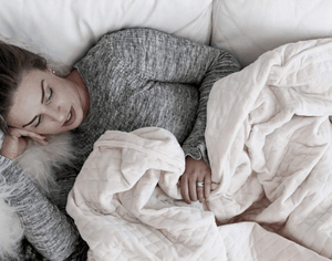 woman covered with weighted blanket - do weighted blankets work?